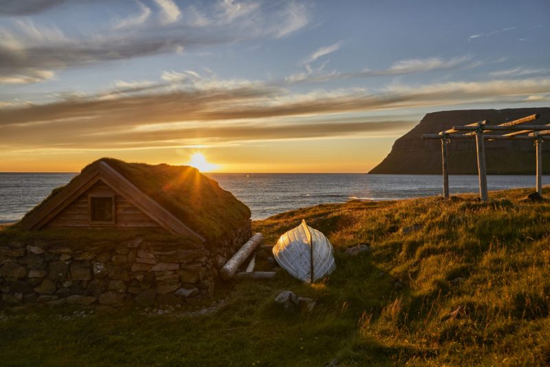 Typisches Grassodenhaus mit Gestell zum Fischtrocknen in der Nähe von Suðureyri